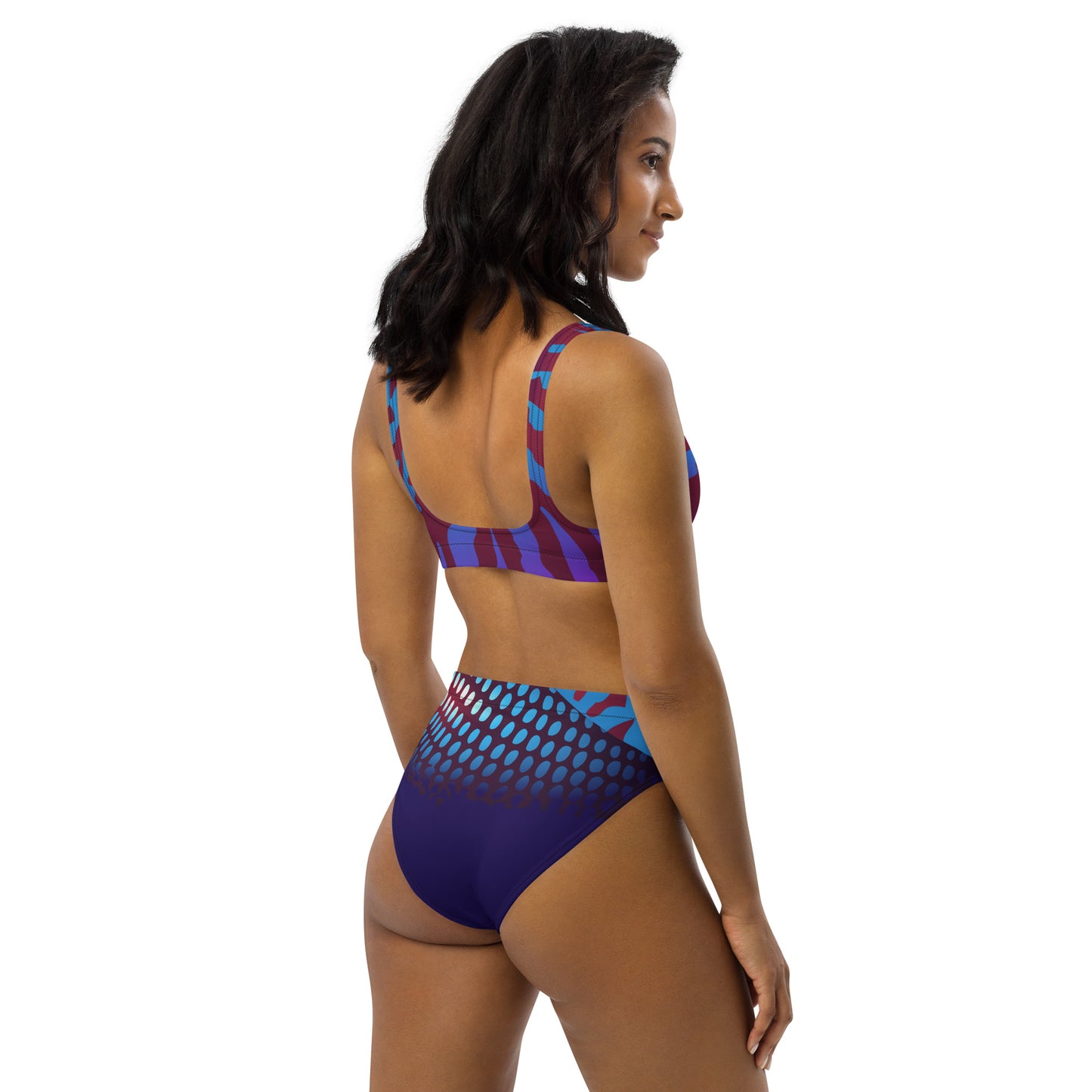 Woman modeling the Betta Ruk Bakini Swimsuit in purples, reds, and blue patterns from the right back.