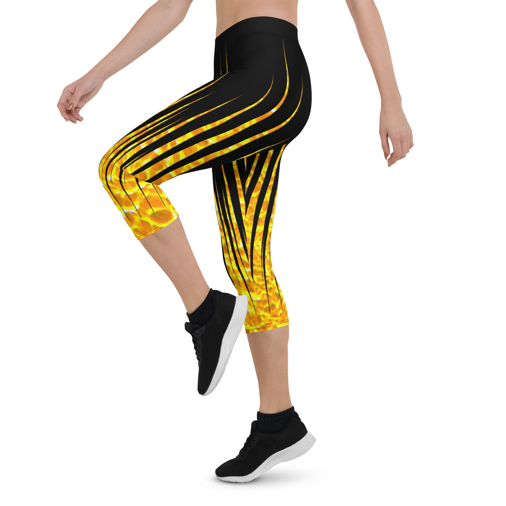 Woman modeling the Black and Fire printed Fired Up Capri leggings high-stepping from the side.