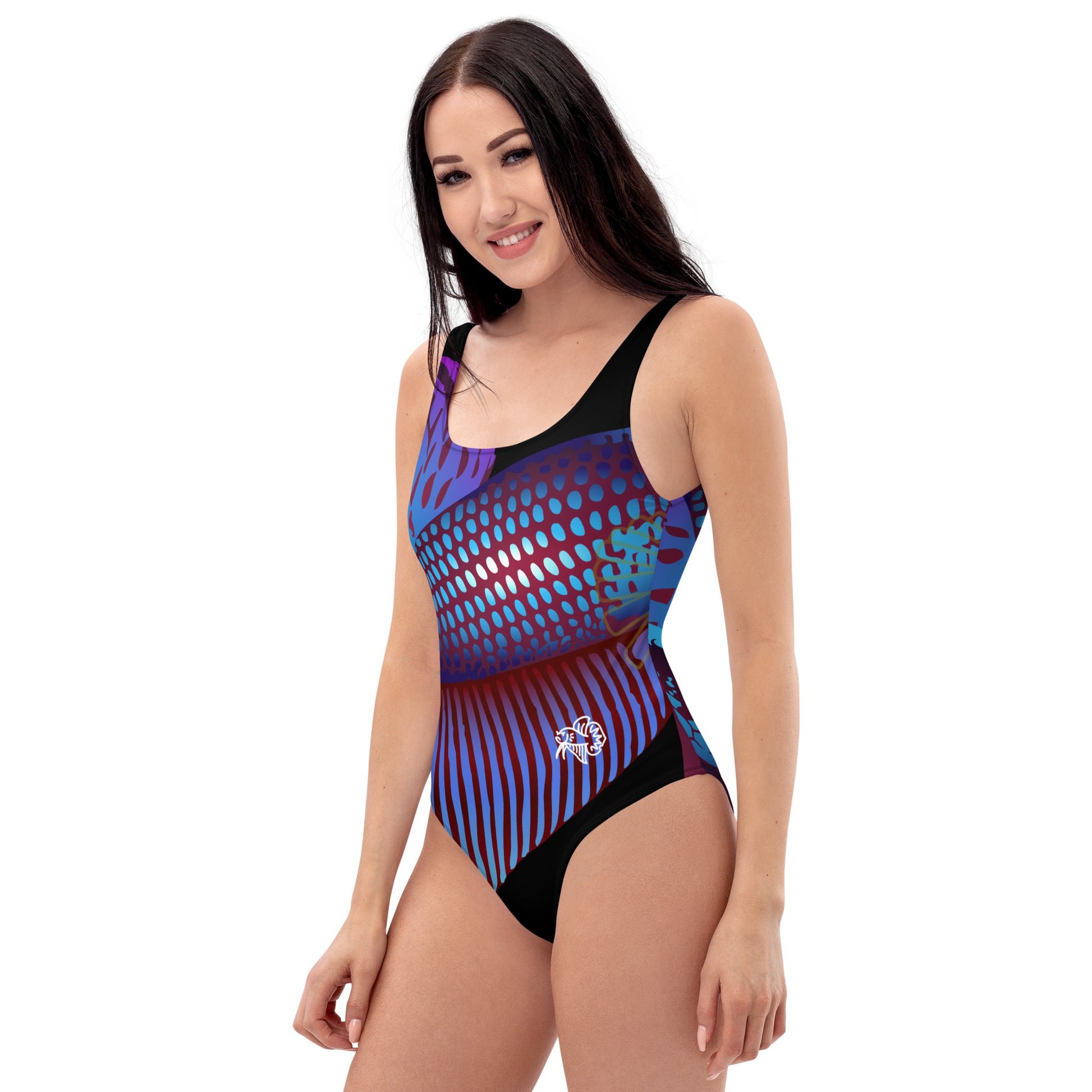 Woman modeling the Betta Ka One Piece Swimsuit in purples, reds, and blue patterns from the right front.