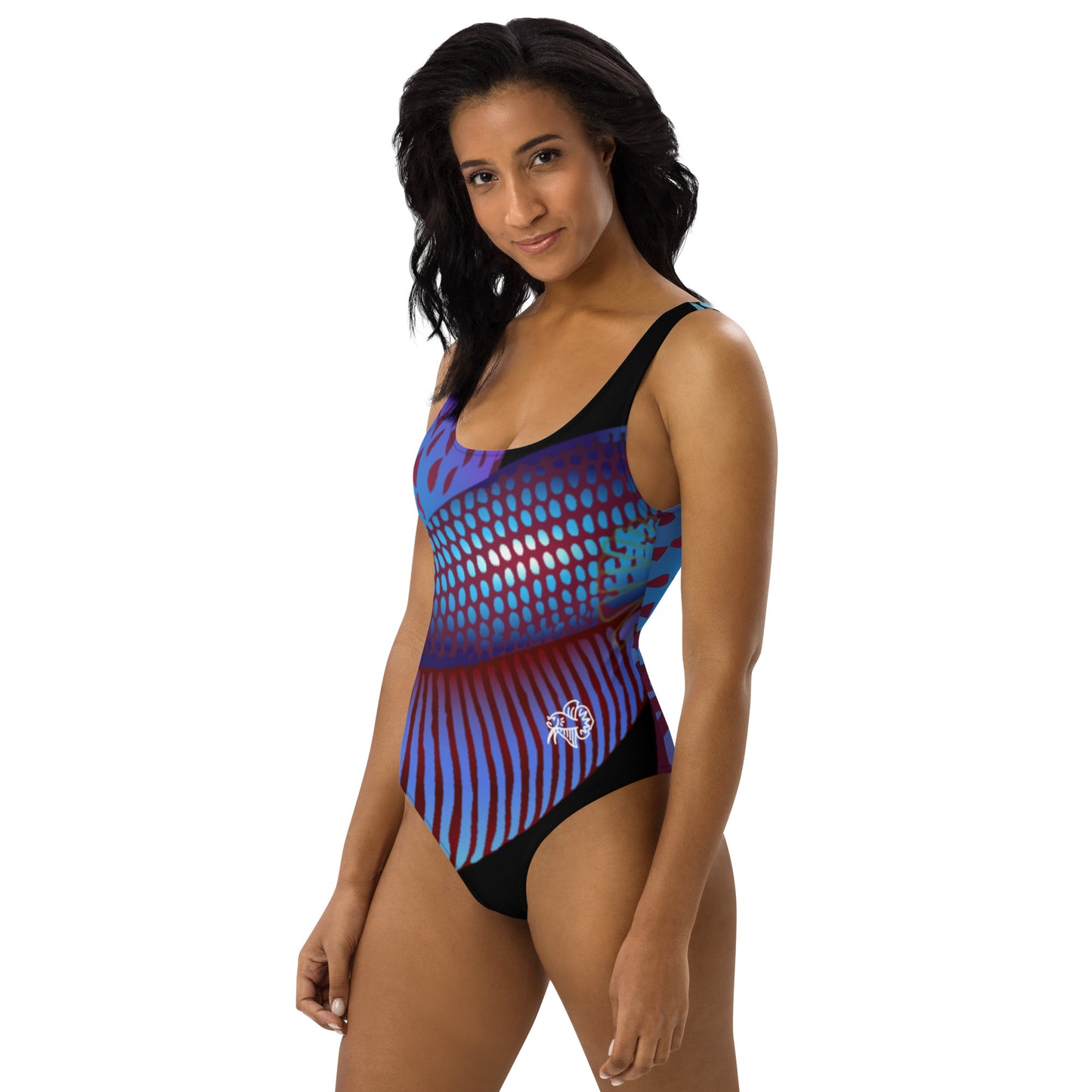Woman modeling the Betta Ka 1 piece swimsuit in purples, reds, and blue patterns from the left front.