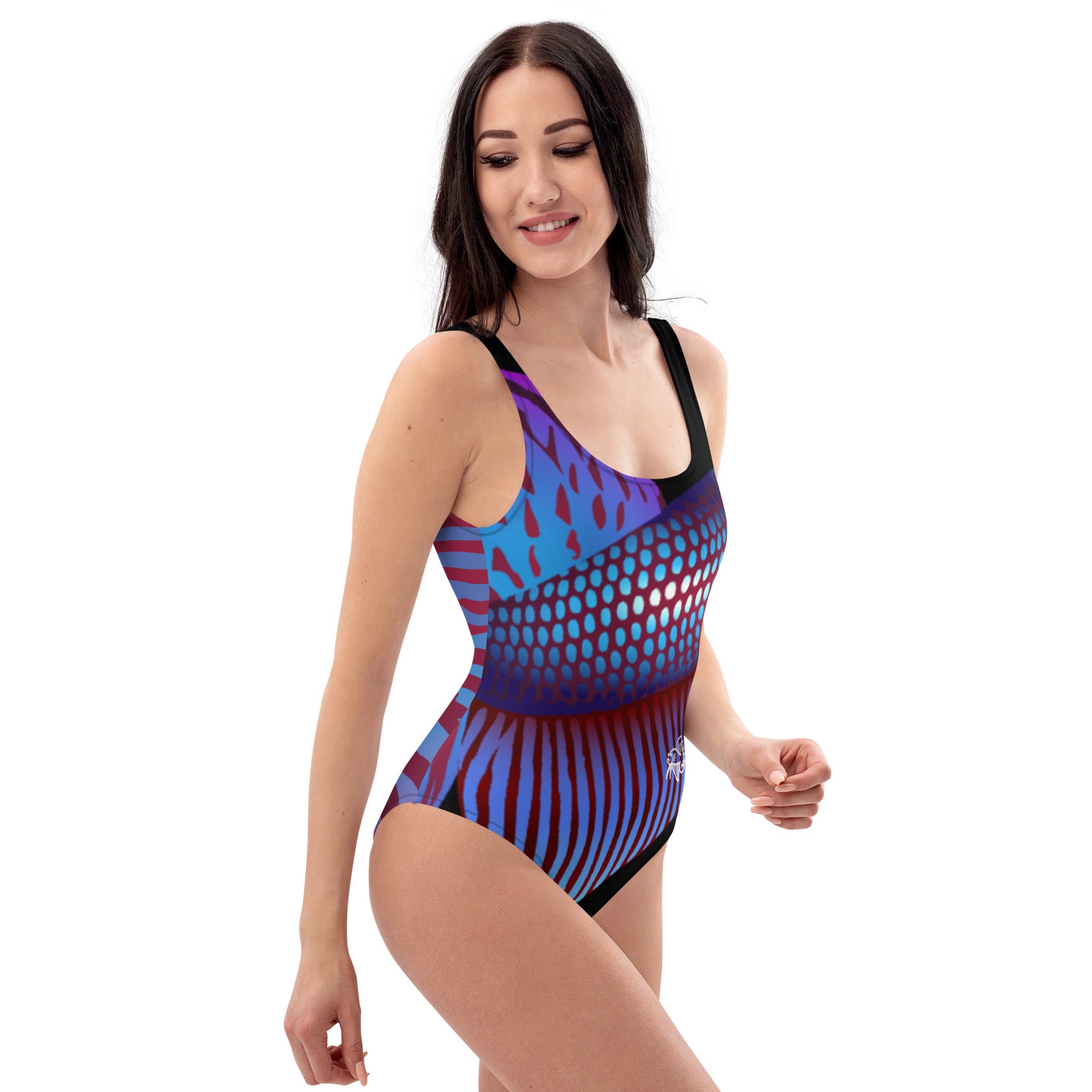 Woman Wearing the Betta Ka one-piece swimsuit in purples, reds, and blue patterns from the right front.