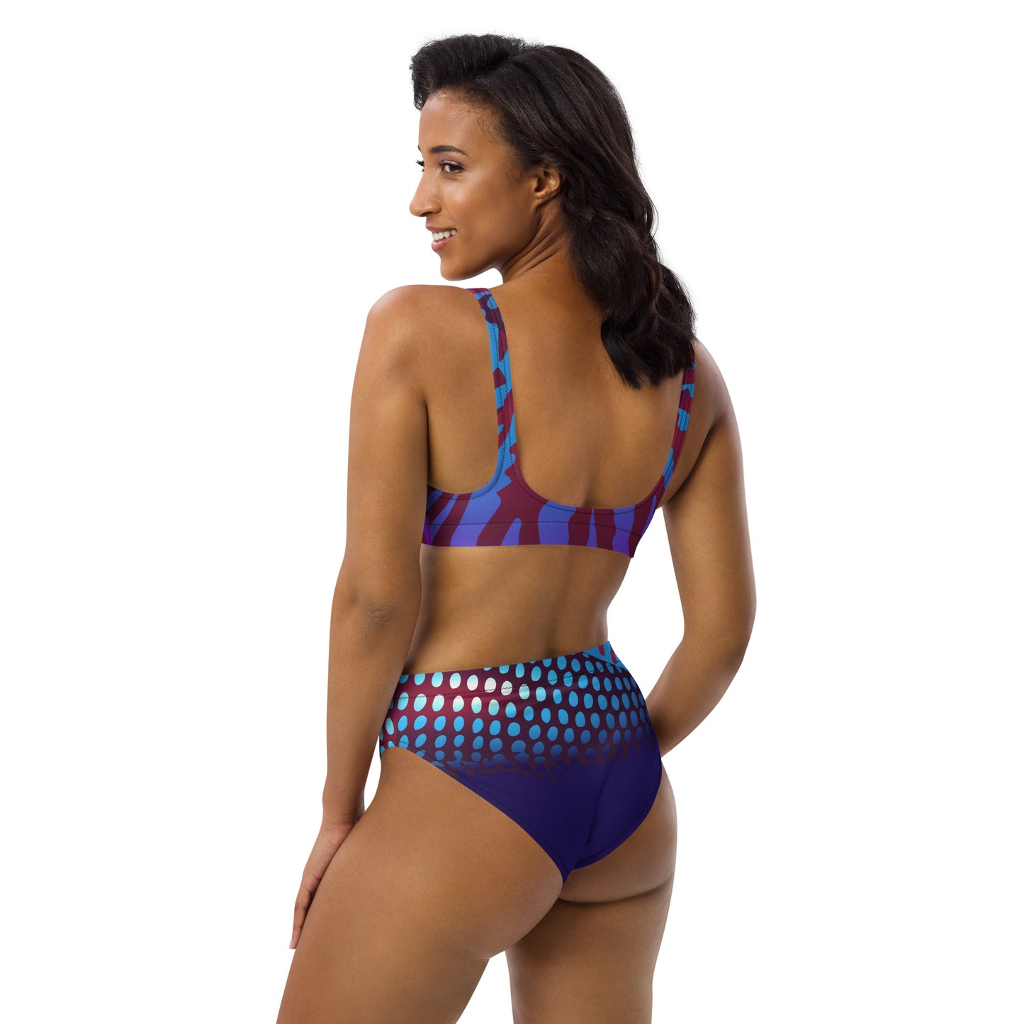 Woman modeling the Betta Ruk Bakini Swimsuit in purples, reds, and blue patterns from the left back.