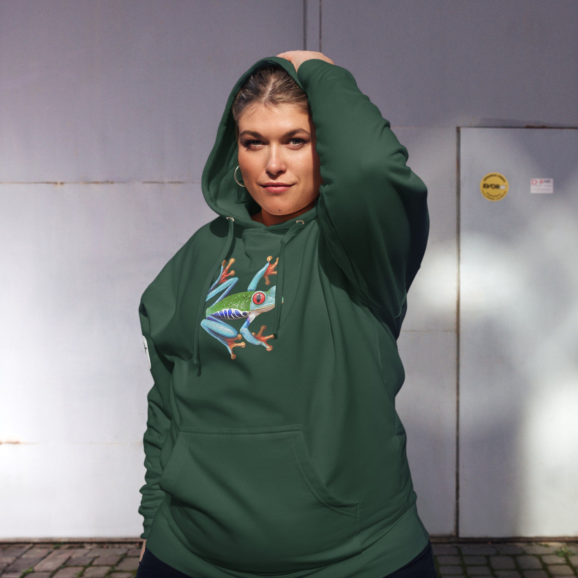 Female model wearing the Anura Sigma hoodie in green from the front.